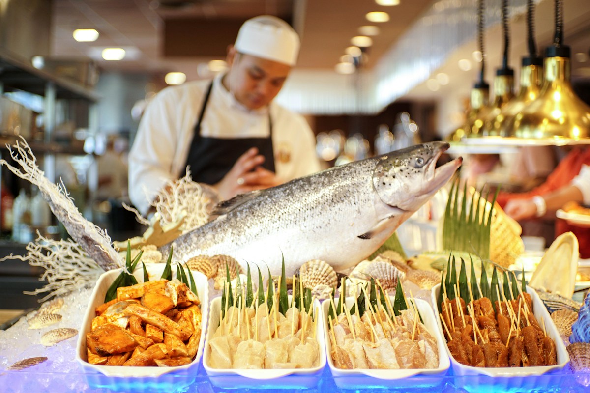 Man in white apron holding fish in the Philippines